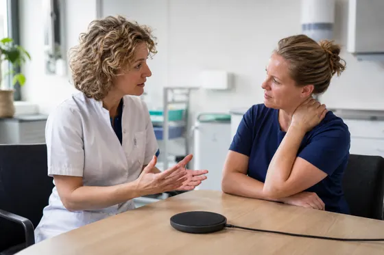 Arboverpleegkundige bespreekt werkbelasting en herstel met een werknemer