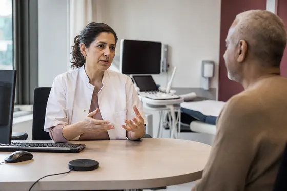 Internist bespreekt medische informatie met een oudere patiënt
