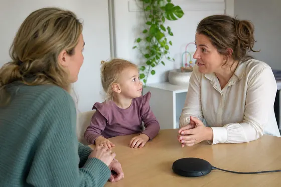 Jeugdverpleegkundige spreekt een ouder met baby op het consultatiebureau