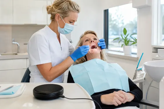 Mondhygiënist behandelt het gebit van een cliënt in de tandartsstoel