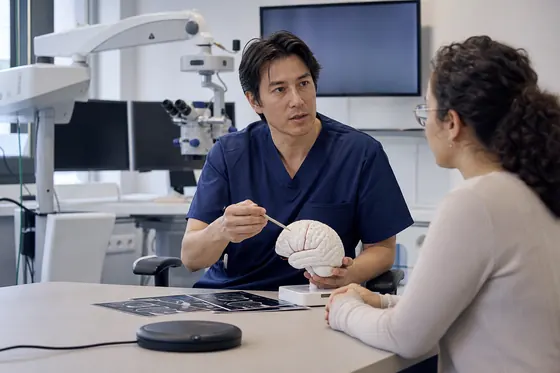 Neurochirurg legt een ingreep uit met een hersenmodel