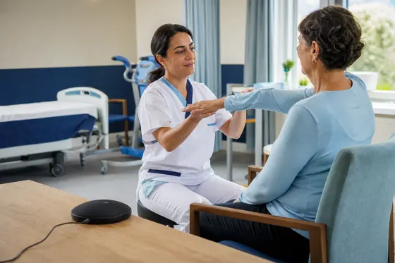 Verpleegkundige geeft uitleg aan een patiënt op de stroke unit