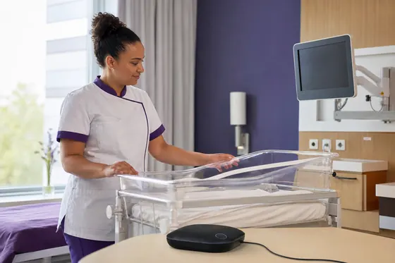 Obstetrieverpleegkundige verzorgt een babybed in de ziekenhuiskamer