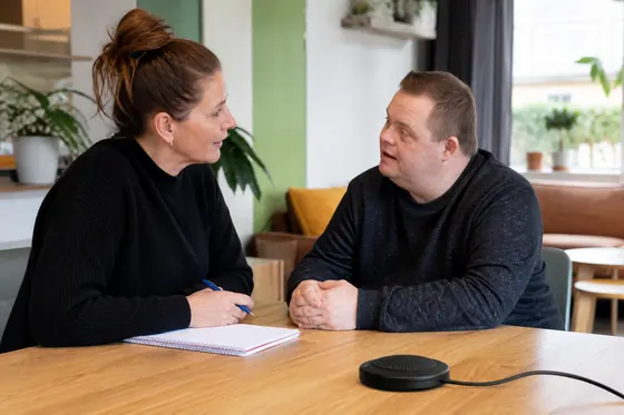 Persoonlijk begeleider ondersteunt een cliënt tijdens een huisbezoek