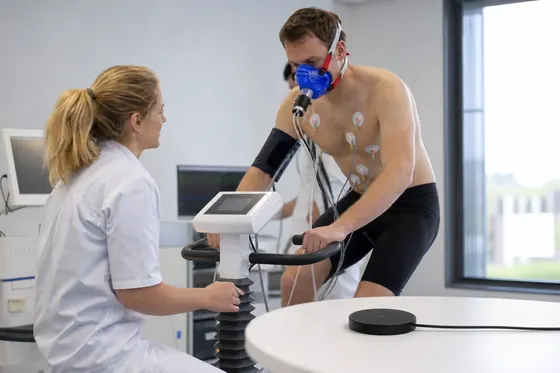 Sportarts begeleidt een cliënt tijdens een inspanningstest op de loopband